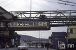 Ein Schwebebahnwagen verlässt die Wendescheife in Wuppertal-Oberbarmen und fährt in die gleichnamige Station ein. Im Hintergrund ist das Empfangsgebäude des alten Bahnhofs Oberbarmen zu erkennen.  (22.06.1970) <i>Foto: Robin Fell</i>