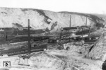 Blick auf die Kalksteinbrüche und Natursteinfelsen Pater und Nonne zwischen Letmathe und Iserlohn. In der Bildmitte rollt 93 976 vor P 1310 dem Bahnhof Letmathe entgegen. (04.1932) <i>Foto: DLA Darmstadt</i>