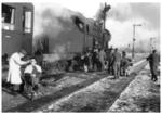 Während ein Truppentransport im winterlichen Bahnhof Siedlce auf Weiterfahrt wartet, wird die Zeit zum Haareschneiden genutzt. (1942) <i>Foto: RVM (Bandelow)</i>