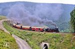 99 7235 mit einem Sonderzug im Drängetal kurz vor dem Thumkuhlenkopftunnel zwischen Steinerne Renne und Drei Annen Hohne. Als man das Wort 'Klimawandel' noch gar nicht kannte, gab es schon Baumsterben im Harz. Heute machen Trockenheit & Schädlingsbefall, wie durch den Borkenkäfer, dem Fichtenwald zusätzlich zu schaffen. (16.06.1990) <i>Foto: Wolfgang Bügel</i>