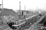 211 030 vom Bw Leipzig Hbf West verlässt mit einem Personenzug den Hauptbahnhof Naumburg (Saale). Links befindet sich das frühere Bahnbetriebswerk, das 2010 abgerissen wurde. (01.12.1986) <i>Foto: Thomas Fischer</i>