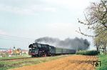 01 0517 vor dem P 3025 von Leipzig Hbf nach Saalfeld (Saale) bei Neustadt (Orla) auf Höhe von Dreitzsch. Dort hatten fleißige Genossen schon für den anstehenden "Internationalen Kampf- und Feiertag der Werktätigen" (1. Mai) geflaggt. (18.04.1981) <i>Foto: Helmut Dahlhaus</i>