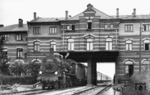 Die Rostocker 38 1575, eine mecklenburgische P 8, unterfährt mit D 7 die ehemalige Eingangshalle des ersten Warnemünder Bahnhofs, der von 1886 bis 1903 bestanden hat. Das Bahnhofsgebäude wurde bei der Streckenverlängerung zum neuen Fährbahnhof in Warnemünde im Jahre 1903 untertunnelt. Das Kuriosum verschwand erst 1984 mit der Streckenelektrifizierung. (1926) <i>Foto: DLA Darmstadt (Bellingrodt)</i>