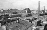 Der Güterbahnhof des Bahnhofs Halle (Saale) Hbf war neben dem Bahnhof Dresden-Friedrichstadt einer der bedeutendsten Güterbahnhöfe im Netz der Deutschen Reichsbahn mit einer durchschnittlichen Bergleistung von 2000 Wagen (Nordberg) und 1600 Wagen (Südberg) pro Tag. Von hier aus wurde die Kohle aus den Tagebauen des Bezirkes und Erzeugnisse der Chemiegroßbetriebe Leuna, Buna, Wolfen und Bitterfeld weitertransportiert. An der Berliner Brücke über dem Bahnhof in Höhe des Bw Halle (Saale) G rangieren gleich drei preußische G 8¹. Im Hintergrund ist das Ablaufstellwerk Nordberg "Hg 5" zusehen, rechts das Rangierstellwerk "Hg 4". (07.1956) <i>Foto: Jürgen Hagemann</i>