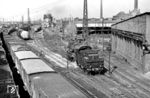Blick von der Berliner Brücke auf das Bw Halle (Saale) G. In Höhe Ringlokschuppen 1 ist die hier beheimatete 58 1427 auf Rangierfahrt unterwegs, die sogar kurzzeitig 1951/52 mit Kohlenstaubfeuerung ausgerüstet war. Das Bw G (G = Güterzugdienst) setzte seine Lokomotiven vornehmlich im Güterzug- und Rangierdienst ein. Im Hintergrund steht die Kohlenstaub-Bunkeranlage, davor sind zahlreiche Kohlenstaub-Behälterwagen und Kohlenstaub-58er abgestellt. Hier begann 1930 auch die Ära der Kohlenstaublokomotiven. (07.1956) <i>Foto: Jürgen Hagemann</i>