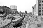 Ein ET 165 der Zuggruppe 1a auf der Fahrt von Berlin Anhalter Bf nach Berlin-Wannsee in Berlin-Schöneberg. Der Blick von der Julius-Weber-Brücke im Verlauf der Kolonnenstraße geht in Richtung Südwesten auf die Wannseebahn zum Bahnhof Schöneberg. Links ist das Gaswerk Schöneberg zu sehen. Der Zug unterquert im Kreuzungsbauwerk die einstige Potsdamer Fernbahn (Stammbahn), von der nur noch ein Gleis zum Potsdamer Güterbahnhof führt. Der Einschnitt wird auch "Berliner Tal" genannt, weil hier in der Eiszeit ein Urstromtal verlief. (06.1960) <i>Foto: Jürgen Hagemann</i>