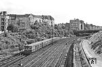 Ein ET 169 der Bauart 'Bernau', angeglichen an die Bauart 'Stadtbahn', auf der Ringbahnstrecke am S-Bahnhof Westend. Die Zuggruppe C fuhr von der Warschauer Straße über den Nordring nach Berlin-Gartenfeld oder Berlin-Halensee. Der Fotograf steht auf der Knobelsdorffbrücke und blickt nach Süden auf die Kurfürstendamm-Brücke. Links am Rand ist das Ende der südlichen Kehranlage des Bahnhofs Westend zu sehen, rechts beginnen die Bauarbeiten für die Stadtautobahn A 100. (07.1960) <i>Foto: Jürgen Hagemann</i>