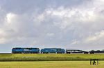 RDC 2700-07 schleppt die defekte 247 909 vor dem Autozug DPF 28914 auf dem Hindenburgdamm östlich von Morsum ab. Die RDC-Gruppe hat für den Autozug Sylt am Rande der Innotrans 2026 zwei Vectron X Dual Mode bei Siemens bestellt, die die veralteten DE 2700 ersetzen sollen. (29.08.2026) <i>Foto: Joachim Bügel</i>