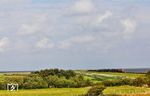 Über den Hindenburgdamm nähern sich 218 390 und 218 385 mit AS 1438 nach Westerland (Sylt). Die Landschaft am östliche Ende Sylts ist vom "Roten Kliff" bei Morsum geprägt. Von hier aus könnte man theoretisch über das Meer bis nach England sehen, wäre da nicht die Erdkrümmung, die es verwehrt. Auch weht der Wind meist besonders stark und verleiht der Küste ihre wilde, unverkennbare Dynamik. Mit einer durchschnittlichen Tiefe von 94 Metern ist die Nordsee ein Flachmeer, doch vor Sylt fällt der Meeresboden schon nach wenigen hundert Metern auf bis zu zehn Meter ab. Dieser steile Strandabfall, einzigartig im Vergleich zu anderen Wattenmeer-Inseln, sorgt nicht nur für die besten Surfbedingungen an der gesamten deutschen Nordseeküste, sondern schützt auch ein wertvolles Rückzugsgebiet für Schweinswale. (29.08.2026) <i>Foto: Joachim Bügel</i>