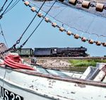 Motivwahl ist alles: Der Blick durch ein Fischernetz gibt die Aussicht auf 012 071 frei, die vor E 2111 nach Hamburg-Altona in Husum einfährt. (07.1971) <i>Foto: Ulrich Hesse</i>