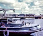 Im Frühjahr 1967 waren die ersten kohlegefeuerten 01.10 von Osnabrück nach Rheine versetzt worden und lösten die Baureihe 03 auf der Emslandstrecke ab. 01 1097 gehörte seit 1. April 1967 dem Bw Rheine an und fährt hier mit dem D 65 aus Köln über die Klappbrücke am Emder Binnenhafen, die später zu einem beliebten Motiv vieler Eisenbahnfotografen werden sollte. (04.1967) <i>Foto: Ulrich Hesse</i>