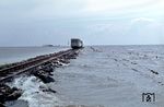 Die meterspurige Inselbahn Juist war die erste motorbetriebene Inselbahn Deutschlands und wurde 1982 stillgelegt, nachdem ein neuer ortsnaher Hafen errichtet worden war. Durch das Wattenmeer kehrt der T 3 (Talbot, Baujahr 1950, ex Geilenkirchener Krb) von der Landungsbrücke zurück auf die Insel. (04.1971) <i>Foto: Jürgen Hagemann</i>