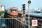 Eine U 3 nach Barmbek fährt in die Station Landungsbrücken ein. Der U-Bahnhof ist ein wichtiger Verkehrsknotenpunkt, in der zwischen U-Bahn und S-Bahn umgestiegen werden kann, der aber auch über eine Bus- sowie eine Fähranbindung verfügt. Der Bahnhof ist einer der ältesten in Hamburg, wurde 1912 eröffnet und steht heute unter Denkmalschutz. Etwa 29.000 Menschen nutzen täglich die Station. (06.1971) <i>Foto: Jürgen Hagemann</i>