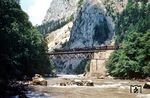 Eines der schönsten Motive entlang der Gesäuse-Strecke ist die Ennsbrücke am Gesäuse Eingang mit dem Himbeerstein im Hintergrund. Zwischen den Bahnhöfen Gstatterboden und Admont fahren zwei 52er vor einem Erzzug über das markante Bauwerk. Zuglok ist 52.4364, die zeitweise als Versuchsträger der ÖBB zur Optimierung des Kohleverbrauchs diente. In dem Brennstoff-Versuchstender war in der Zugführerkabine der Meßstand verbaut.  (07.1969) <i>Foto: Jürgen Hagemann</i>