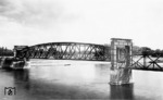 Die Hubbrücke Magdeburg an der Strecke Magdeburg-Buckau - Elbbahnhof - Brückfeld - Biederitz überspannt die Elbe bei Stromkilometer 325,47. Sie ist mit Baujahr 1895 eine der ältesten und mit 220 m und 90 m Stützweite eine der größten Hubbrücken Deutschlands. Zwischen 1933 und 1934 erfolgte der letzte Umbau, dessen Zustand auf dem Foto dokumentiert ist. Am 16. April 1945 wurde das Bauwerk von deutschen Truppen gesprengt, mittels Hilfsbrücke im Juli 1945 wieder befahrbar. Am 28.02.1998 wurde der Zugverkehr über die Brücke eingestellt. Aufgrund der defekten Hubvorrichtung wurde das Bauwerk im Juni 2001 in angehobenen Zustand arretiert. (1935) <i>Foto: RVM</i>