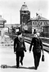 Zwei Reichsbahnerinnen auf dem Weg zum Dienst im Bahnhof Eßlingen (Neckar). Zur Kompensation des während des Zweiten Weltkriegs rapide ansteigenden Personalmangels wurden neben Zwangsarbeitern und Kriegsgefangenen auch Frauen massiv zur Deutschen Reichsbahn verpflichtet, die bis Ende 1943 bereits 190.000 Frauen beschäftigte. (1942) <i>Foto: RVM (Breuer-Courth)</i>