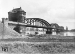 Die 961 m lange Brücke überspannte den Rhein als Teil der Bahnstrecke Worms—Biblis nördlich von Worms. Die am 30. November 1900 eingeweihte Brücke wurde am 20. März 1945 gesprengt. An ihrer Stelle wurde 1948 eine eingleisige Behelfsbrücke erstellt, die 1960 durch einen neuen Brückenzug ersetzt wurde. Von 2009 bis 2012 wurden die noch größtenteils aus dem Jahr 1900 stammenden Überbauten der rechtsrheinischen Vorlandbrücke durch einen neuen Überbau mit einer Schotterfahrbahn ersetzt. Ab 2. April 2012 war die Brücke wieder zweigleisig befahrbar. (1935) <i>Foto: Adam Raisch</i>
