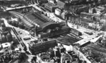 Luftaufnahme des Hamburger Hauptbahnhofs mit seiner gewaltigen 73 m Spannweite umfassenden Bahnsteighalle. Bemerkenswerte Details auf dem Foto sind: Auf der Hannover'schen Seite des nördlichen Vorfelds die Rangiergruppe mit einer Lok der BR 78 und zwei Oberlicht-D-Zugwagen, auf der Berlin-/Lübecker Seite im Gleisvorfeld eine Reisezuwagengruppe aus einem Oberlicht-D-Zug- und einem 4-achsigen Abteilwagen sowie beiderseits eines Gepäckbahnsteigs je ein 4-achsiger Einheits- und ein preußischer Gepäckwagen. Am Gepäckbahnsteig des Berliner Bahnsteigs im südlichen Vorfeld ein weiterer abgestellter 4-achsiger preußischer Gepäckwagen. Unmittelbar neben dem Reiterstellwerk 'Hp' steht eine Rangierlok mit Postwagen, auf einem der Passagegleise eine Reisezugwagengruppe mit LBE-Wagen und am Hannover'schen Bahnsteig wartet ein Personenzug mit 3-achsigen Abteilwagen auf die Ausfahrt. (1934) <i>Foto: RVM</i>