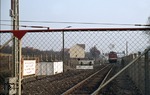 Blick durch den Grenzzaun auf eine V 100 der Reichsbahn, die im Bahnhof Ellrich unter Bewachung der DDR-Grenzorgane rangiert. (01.11.1972) <i>Foto: Peter Schiffer</i>
