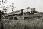 Der reguläre Reiseverkehr auf der ehemaligen Dessau-Wörlitzer Eisenbahn war schon im Mai 1968 eingestellt worden, doch am 23.5.1982 lief ein saisonaler Ausflugsverkehr an, der ein voller Erfolg wurde. Der Fahrplan mußte schon bald ausgeweitet und die anfängliche Kleinlok durch eine größere Lok der Baureihe 106 ersetzt werden. Hier fährt 106 184 (Bw Roßlau) mit dem P 16064 nach Wörlitz zur Muldebrücke hinauf. (19.09.1982) <i>Foto: Hans-Joachim Simon (Archiv Ludger Kenning)</i>
