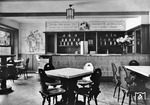 Blick in die Bahnhofsklause des Düsseldorfer Hauptbahnhofs mit dem einladenden Wandspruch "Westfälischer Schinken, Rheinischer Wein, Pommersche Gans, ein Hecht aus dem Main, Schwarzwälder Kirsch und ein Mädel aus Schwaben, das sind die allerbesten Gottesgaben". (1936) <i>Foto: RBD Wuppertal (Eckler)</i>