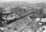 Übersichtsaufnahme des entgleisten D 24 (Malmö - Berlin) und der umgekippten 03 1057 (rechts oben) an der Havelbrücke in Fürstenberg. Dass es bei dem Unfall "nur" 3 Tote gab, (auf dem Führerstand starben Lokführer, Heizer sowie ein mitfahrender Lokfahrmeister des Bw Stralsund) ist der Kastenbauform der Brücke zu verdanken. Dadurch stürzte die vor der Brücke entgleiste Lok nicht in die Havel und hätte ansonsten den Zug mit sich gerissen, was weitaus schlimmere Folgen gehabt hätte. Vorne steht der Hilfszug mit 41 262 vom Bw Neustrelitz. (25.11.1963) <i>Foto: Slg. Erich Preuß</i>