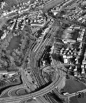 Luftaufnahme des Tübinger Hauptbahnhofs mit der prägnanten Straßenbrücke der B 28. Am oberen Bildrand ist der Neckar zu erkennen, das Bahnbetriebswerk fehlt auf dieser Aufnahme, es liegt unterhalb der Straßenbrücke. (1983) <i>Foto: Slg. Erich Preuß</i>