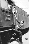 Übergabe des Bremszettels vom Zugführer an den Lokführer der Erfurter 01 205. Der Bremszettel enthält u.a. Informationen über Achsenzahl, Zuggewicht und Bremsverhältnisse des Zuges. (1962) <i>Foto: Slg. E. Preuß</i>