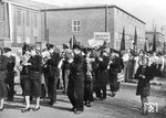 Am 31. August 1945 befahl die Sowjetische Militäradministration in Deutschland (kurz: SMAD) dem Präsidenten der Zentralverwaltung des Verkehrswesen die Reparatur von Lokomotiven und Wagen zu organisieren. Allein in der sowjetisch besetzten Zone gab es knapp 5.000 Lokomotiven und 33.000 Waggons. Dies war der Startschuss für die Wiederaufnahme des Betriebes im Ausbesserungswerk. Im Werk Dessau arbeiteten im Oktober 1945 bereits wieder 845 Mitarbeiter, aber die Zahl der Mitarbeiter war immer noch niedriger als die während des Krieges. Nach dem Potsdamer Abkommen, das besagte, dass alle Kriegsbetriebe zu demontieren seien, fiel auch das Ausbesserungswerk Dessau unter diese Bestimmung, da im Werk Teile für die Junkersflugzeuge gefertigt wurden. 1946 begann die Demontage im Werk mit dem Abbau der elektrischen Zugförderung. Erst Ende 1952 mit der Rückführung beschlagnahmter Elektrolokomotiven, Anlagen, Ersatzteilen und Fahrzeugen der elektrischen Zugförderung aus der Sowjetunion wurde die Instandhaltung von Elektrolokomotiven im Werk Dessau wieder aufgenommen. Das Werk war nun ein Werk im Instandhaltungskonzept der Deutschen Reichsbahn. Das Bild zeigt den Schalmeienchor des RAW anlässlich der Feierlichkeiten zum 1. Mai.  (01.05.1953) <i>Foto: Slg. Erich Preuß</i>