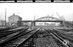Blick auf die Ostausfahrt des Bahnhofs Wuppertal-Oberbarmen mit der alten Güterabfertigung und der Straßenbrücke zum Höfen, die bezeichnenderweise im Volksmund "Schwindzugbrücke" genannt wurde. Als Kind hatte man hier den besonderen Spaß, dass der Dampf der ausfahrenden Züge durch die Holzbohlen quoll und die Brücke von allen Seiten völlig eingenebelt wurde - für den Straßenverkehr war diese Situation allerdings nicht so prickelnd, daher wurde die Brücke im Zug der Elektrifizierung (!) auch abgerissen und durch eine geschwungene Fußgängerbrücke ersetzt. (10.02.1962) <i>Foto: BD Wuppertal (Säuberlich)</i>