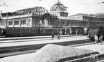 Zwei Jahre nach Ende des Zweiten Weltkriegs waren die Kriegsschäden in Nürnberg Hbf noch unübersehbar. Neben der bunt zusammengewürfelten Zuggarnitur vor dem Empfangsgebäude haben Loks der Baureihen E 18 und E 04 die elektrische Zugförderung wieder übernommen.  (1947) <i>Foto: Autor unbekannt</i>