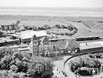 Blick vom alten Leuchtturm auf den Bahnhof Wangerooge. Das Empfangsgebäude zierte die prägnante Inschrift "Kehre wieder". (08.1973) <i>Foto: Peter Wagner</i>