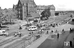 Blick auf die Westausfahrt des Oldenburger Hauptbahnhofs mit dem BÜ an der Raiffeisenstraße. Rechts hinten ist der Bahnhof zu erkennen. Zwischen 1963 und 1966 wurden die Gleise hochgelegt und alle Bahnübergänge beseitigt. Im imposanten Gebäude hinter dem Bü war in früherer Zeit die Verwaltung der Olderburger Bahndirektion untergebracht. (23.05.1962) <i>Foto: Quebe</i>