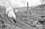 Im leichten Schneetreiben macht sich 86 1608 vor den damals noch umfangreichen Betriebsanlagen von Bahnhof und Bw Annaberg-Buchholz Süd auf den Weg nach Schlettau, um von dort aus die Zugleistungen auf der Stichstrecke nach Crottendorf ob Bf zu übernehmen. Im Bahnhof steht ein weiterer Güterzug nach Cranzahl bereit. (22.04.1976) <i>Foto: Joachim Bügel</i>
