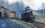 99 1568 erreicht mit Ng 66512 den Bahnhof Jöhstadt. Vor dem Schuppen steht die ihrer Schilder (nicht vom Fotografen !) beraubte 99 1582.  (21.04.1983) <i>Foto: Wolfgang Bügel</i>