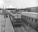 E 11 011 (Bw Halle P) fährt in den Bahnhof Leuna Werke Nord ein. In Leuna befand sich während des Zweiten Weltkrieges, mit den Leunawerken der I.G. Farben, das größte Hydrierwerk Deutschlands. Die Anlage erzeugte aus Kohle Leuna-Benzin und deckte unter anderem einen Teil des Treibstoffbedarfs der Wehrmacht und war Quelle des Flugbenzins für die Luftwaffe. Die Leunawerke kamen nach Ende des Zweiten Weltkriegs und der Zerschlagung der I.G. Farben in sowjetischen Besitz. 1954 wurden die Leunawerke in "Volkseigentum" überführt. Offiziell hieß das Werk VEB Leuna-Werke „Walter Ulbricht“ (LWWU) und war der größte Chemiebetrieb der DDR. Auf dem Gebiet der Stadt Leuna befinden sich die Haltepunkte Leuna Werke Nord (Foto) und Leuna Werke Süd an der Bahnstrecke Halle – Naumburg, die nur dem Werksverkehr dienen und von denen ein direkter Zugang zur Stadt nicht möglich ist. Der eigentliche Bahnhof Leuna lag an der Nebenbahn Merseburg - Wallendorf - Leipzig-Leutzsch und wurde 1998 stillgelegt. (16.03.1966) <i>Foto: Joachim Claus</i>