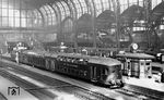 Wendezug der ehemaligen Lübeck-Büchener-Eisenbahn - nach der Verstaatlichung durch die Deutsche Reichsbahn - in Hamburg Hbf mit der schiebenden 60 003 (erkennbar an dem längeren Wasserkasten und dem nur bei 60 003 eingebauten Kuckuck-Lüfter mit Ventilator auf dem Führerhaus). Die Doppelstockwagen sind trotz Umbeschriftung auf "Deutsche Reichsbahn" und Löschen (Überlackieren) der zuvor an der Stirnwand angeschriebenen Wagennummer (DW 1-2 und DW 3-8) noch im zweifarbigen Anstrich grau/gelb belassen und nicht komplett nach Reichsbahn-Vorschrift umlackiert. (1938) <i>Foto: Hans Hartz</i>