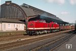 Mit einem Güterzug rollen DR 110 655 (Bw Gera) und eine unbekannte Schwesterlok an der unverkennbar 1911 erbauten Bahnhofshalle von Gera Hbf vorbei. (1979) <i>Foto: Robin Fell</i>