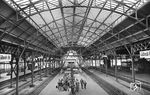 Blick in die restaurierte Bahnhofshalle von Lübeck Hbf. Der Bahnhof wurde 1908 nach einem Entwurf von Fritz Klingholz von der Lübeck-Büchener Eisenbahn (LBE) erbaut, die damals den größten Teil der Eisenbahnverbindungen rund um Lübeck einschließlich der Schnellzugverbindungen betrieb. Von 1945 bis 1990 war Lübeck Grenzbahnhof zur DDR. Der Bundesgrenzschutz hatte auf dem östlichsten Bahnsteig eigene Grenzkontrollanlagen. Diese mussten von allen in Lübeck in die etwa ein bis zwei Mal täglich nach Rostock verkehrten Interzonenzüge zusteigenden Reisenden passiert werden. Seine größte Bedeutung erlangte der Lübecker Hauptbahnhof mit Inbetriebnahme der Vogelfluglinie von Hamburg nach Skandinavien seit dem 14. Mai 1963.  (02.06.1958) <i>Foto: Walter Hollnagel</i>