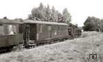 Der KPw4i 974-451, hier im P 9201 (Altefähr – Putbus) hinter der 99 553 in Karnitz, war ursprünglich ein 1913 in Werdau gebauter sächsischer Traglastenwagen 4. Klasse, bis er von Mai bis August 1954 im Raw Karl-Marx-Stadt zum Preis von 20.291 M für Putbus in einen kombinierten Gepäck-/Sitzwagen umgebaut wurde. Als CPwtr besaß er nun ein Dienstabteil (2,75 qm, mit Schreibpult und Ofen), ein Packabteil (12,3 qm, mit Seilrollenbock für die Gewichtsbremse), ein Sitzabteil (6,7 qm, mit 18 Sitzplätzen auf Holz-Längsbänken, Abort und Ofen) sowie zwei innen laufende Schiebetüren, einen Dynamo (24 V, 30 A) mit Riemenantrieb für die Lichtstromversorgung des Wagenzuges sowie eine über das Bremsgestänge der Spindelhandbremse betriebene Gewichtsbremse. Vorerst behielt er seine Holzbeplankung. Später – vermutlich im Juni 1961, als eine R4-Untersuchung mit 11.252 M zu Buche schlug – entfernte man das Sitzabteil und verkleidete den Wagen mit Blech. Bei einer Begutachtung am 31.8.1961 bezeichnete man ihn bereits als „KPw4“ und befand den Zustand seiner Drehgestelle für gut bzw. seines Wagenkastens für „ziemlich gut“. Zugleich wurde im Betriebsbuch vermerkt, daß er noch alte Radsätze mit Sprengringen besaß, und außerdem: „Abteil nicht mehr vorhanden, daher jetzt Tragfähigkeit 5,5 t und Ladegewicht 5,0 t“. Ab 1963 bereitete die Lichtmaschine häufig Probleme, dann schickte man sie defekt nach Perleberg, wo sie verschwand. Erst auf mehrere Mahnungen hin fand man sie wieder, reparierte sie und sandte sie mit einer Entschuldigung zurück nach Putbus. Nach der R2-Untersuchung 1965 fiel die Maschine abermals ständig aus. Im Januar 1966 schickte man sie erneut per Wagenpost nach Perleberg, dann tat sich nichts mehr und niemand reagierte auf die Nachfragen der Wagenmeisterei, bis die Wagenwirtschaft der Rbd Greifswald am 31.8.1966 schrieb: „Da dieser Packwagen der einzige mit Gewichtsbremse ist für den handgebremsten Zug der Strecke Altefähr und wir jetzt unbedingt den Park beleuchten müssen, brauchen wir unverzüglich die Lichtmaschine. Der einzige Personenwagen mit Gewichtsbremse und Lichtmaschine (970-787) hatte einen Unfall und befindet sich ebenfalls in Perleberg.“ Am 12.9.1966 wurde die Lichtmaschine schließlich mit dem ausgehenden Wagen 970-781 nach Putbus zurückgeschickt. Mit der Einstellung der Strecke Altefähr – Putbus im September 1967 entfiel der Altefährer Gewichtsbremszug. Da man auf der Bäderstrecke längst mit Druckluft bremste und auf der Nordstrecke genügend Packwagen vorhanden waren, gab es für den Wagen 974-451, der nicht einmal eine Luftleitung besaß, keine Aufgaben mehr. So kam er „auf den Rand“ und wurde mit MfV-Verfügung am 19.12.1967 ausgemustert. Als Toilettenwagen im Schirgiswalder Ferienlager in Putbus war der Wagenkasten bis Sommer 1990 noch gut genug. (20.08.1966) <i>Foto: Detlev Luckmann</i>