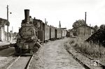 In Altenkirchen wartet die 99 4602 auf Abfahrt nach Fährhof. Rechts der ehemalige, in den 1930er Jahren erbaute Triebwagenschuppen, links schaut das Empfangsgebäude hervor, rechts türmen sich die Kohlenberge der BHG.  (08.1963) <i>Foto: Birger Wilcke (Sammlung Ludger Kenning)</i>