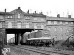 DR 110 510 unterfährt mit einem Personenzug die ehemalige Eingangshalle des ersten Warnemünder Bahnhofs, der von 1886 bis 1903 bestanden hat. Das Bahnhofsgebäude wurde bei der Streckenverlängerung zum neuen Fährbahnhof in Warnemünde im Jahre 1903 untertunnelt. Das Kuriosum verschwand erst 1984 mit der Streckenelektrifizierung. Das Haus war schon immer ein beliebtes Motiv der Fotografen, auch Carl Bellingrodt bannte es bereits 1926 auf Platte (vgl. Bild-Nr. 10655). (16.04.1975) <i>Foto: Joachim Claus</i>