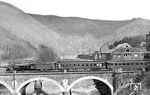 38 2438 (Bw Siegen) überquert mit dem D 81 die Lennebrücke bei Altena (Westf). Diese im ersten Moment unspektuläre Aufnahme des normalen Bahnbetriebs offenbart erst bei genauerem Hinsehen ein paar Besonderheiten: Der erste Wagen (ein C4ü Pr in Stahlbauweise) ist nicht besetzt und fungiert offensichtlich als Schutzwagen, denn der Faltenbalg zum folgenden Wagen ist nicht verbunden. Höchstwahrscheinlich weisen auch die Schilder an beiden Wagenenden (die dann keine Zuglaufschilder sind) auf diesen Umstand hin. Der folgende Wagen ist ein Speisewagen (WR4ü), gebaut im Jahre 1905 von der Waggonfabrik Gotha für Gustav Kromrey (Charlottenburg) als einer von drei Wagen (Berlin 156 bis 158, später wohl Königsberg 0911 bis 0913, dann Mitropa 411 bis 413), dessen Koch gerade einen Blick aus dem Fenster der Tür wirft. Interessanterweise ist an diesem Wagen keine Speisewagenanschrift oder ähnliches zu erkennen ... Dies gibt zu Spekulationen Anlass, dass hier gar nicht der D 81 aufgenommen wurde.  (1930) <i>Foto: DLA Darmstadt (Bellingrodt)</i>