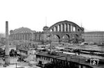 Der Anhalter Bahnhof war einst der bedeutenste Fernbahnhof in Berlin und lag am Askanischen Platz an der Stresemannstraße in der Nähe des Potsdamer Platzes. Er wurde wegen seiner Verbindungen nach Österreich-Ungarn, Italien und Frankreich im Volksmund „Das Tor zum Süden“ genannt. Nachdem das Bahnhofsgebäude am 3. Februar 1945 durch Luftangriffe der Alliierten schwer beschädigt worden und ausgebrannt war, wurde es nur enttrümmert und notdürftig betriebsfähig gemacht. Die vier Hallenwände standen noch und wurden in einer Schadenskarte als wiederaufbaufähig eingestuft. Die eingestürzte Stahlkonstruktion des Hallendaches wurde zerschnitten und entfernt. Nach dem Krieg befand sich der Anhalter Bahnhof durch die erfolgte Sektorenbildung im Westteil Berlins. Der Zugverkehr beschränkte sich aus betrieblichen, aber vor allem aus politischen Gründen, nur noch auf wenige Fern- und Personenzüge in die Sowjetische Besatzungszone/DDR. Ab 1951 verkehrten hier nur noch wenige Nahverkehrszüge nach Brandenburg und Sachsen-Anhalt. Trotz starken Widerstandes der Fachwelt und der Architekten- und Baukammern wurde Ende der 1950er Jahre das seit den 1930er Jahren unter Denkmalschutz stehende Bahnhofsgebäude auf Betreiben des damaligen Berliner Bausenators zum Abbruch freigegeben. 1961 wurde der Bahnhof schließlich gesprengt, lediglich ein Fragment des Bahnhofsportikus blieb erhalten. (25.08.1960) <i>Foto: Gerhard Moll</i>
