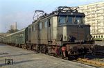 244 127-7 (E 44 127) vom Bw Leipzig-Wahren vor einem Nahverkehrszug in Leipzig Bayerischer Bahnhof. Am 10. Juni 2001 wurde der Betrieb auf dem Bahnhof vollständig eingestellt, nachdem zuletzt noch Regionalzüge in Richtung Altenburg und Zwickau (Sachs) abgefertigt wurden. Um für den Bau des City-Tunnels Platz zu schaffen, wurde der 20 Meter hohe, 30 Meter breite und sechs Meter tiefe sowie 2800 Tonnen schwere Portikus (links hinten) am 10. April 2006 mit Hilfe spezieller Gleitlager um 30 Meter nach Osten verschoben. (1987) <i>Foto: Andreas Höfig</i>