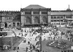 Nach den starken Bombenschäden begann der Wiederaufbau des Empfangsgebäudes im Sommer 1948 in der erhaltenen Außenfassade mit neu zugeschnittenen Innenräumen; die restlichen Stahlkonstruktionen der alten Hallendächer, die hier im Hintergrund noch sichtbar sind, wurden abgetragen und die Bahnsteige erhielten hölzerne Notdächer.  (1948) <i>Foto: Hans Berkowski</i>