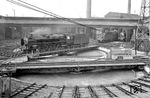 Blick auf die beiden Drehscheiben vor dem 47-ständigen Doppel-Ringlokschuppen des Bw Köln Bbf. Auf einer der Drehscheiben wendet 01 003 vom Bw Hamm (Westf). Im Schuppen rechts stehen: 38 2637 Bw Köln Bbf, 38 1734 Bw Kempen (Rhein) und 38 3152 Bw Deutzerfeld. Die 01 stand zum Zeitpunkt der Aufnahme erst 3 Monate im Einsatz. (03.1927) <i>Foto: RVM</i>