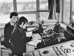 Fahrdienstleiterausbildung, hier die Durchführung von Zugmeldungen und Führung des Zugmeldebuches unter Anleitung, auf dem Fahrdienstleiterstellwerk Berlin-Schönefeld (in der Mitte verläuft der Berliner Außenring in Richtung Grünauer Kreuz rechts biegt das Gleis der Berliner S-Bahn ab). Bei der Reichsbahn der DDR gab es zwar nicht wie bei der DB die Einstellung in das Beamtenverhältnis, die DR übernahm aber inhaltlich auch einige der Laufbahnausbildungen aus der Reichsbahnzeit vor 1945. Zunächst gab es die Ausbildung der "Rb.-Betriebsjunghelfer", die über eine "Aspiranten-Ausbildung" und Dienstanfängerschule in Berlin-Grunewald zur "Prüfung zum n.t. Reichsbahn-Assistenten" führte. Ebenso wurde die Laufbahn der "Rb.-Inspektoren-Anwärter", neu die "A-Ausbildung", zur Prüfung zum "nt. Rb.-Inspektor", die in der Reichsbahnschule Finsterwalde/Niederlausitz erfolgte. Die Facharbeiterausbildungen bei der DR, die damalige  Ausbildung  zum "nt. Rb-Assistenten"  gab es in dieser Bezeichnung  nicht  mehr. Sie wurde qualitativ weiterentwickelt und als "B-Ausbildung" bezeichnet. Auch die Ausbildung zum "Rb-Betriebsjunghelfer" erhielt einen völlig anderen Inhalt und wurde in eine Facharbeiterausbildung überführt. Die Berufsbezeichnung hieß für Schulabgänger der 10. Klasse  "Facharbeiter für Eisenbahnbetrieb" und für Abgänger der 8.Klasse "Eisenbahntransport-Facharbeiter".  Weiterhin wurde ein neuer Lehrberuf bei der  DR eingeführt, und zwar der/die "Verkehrskaufmann"/"Verkehrskauffrau".   (1970) <i>Foto: Historische Sammlung der Deutschen Bahn AG</i>