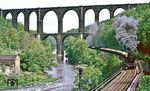 Der Göhrener Viadukt gehört neben der Elster- und Göltzschtalbrücke zu den eindrucksvollsten deutschen Brückenbauten aus der Frühzeit des Eisenbahnbaues. Sie überspannt das Tal der Zwickauer Mulde mitsamt der Muldentalbahn mit einer Höhe von 68 Meter, teilweise in zwei Etagen.50 3516 vor der Kulisse des Göhrener Viadukts, über das die Bahnstrecke Leipzig - Chmenitz (damals noch Karl-Marx-Stadt) führt. Die Länge des Viadukts beträgt 381 m, ursprünglich 512 m mit 12 (ursprünglich 21) Öffnungen oben, die größte Spannweite eines Bogens beträgt 16 m. Das Mauerwerk nimmt ein Volumen von 55.514 m³ ein. Durch Verfüllung der Bögen an den Enden des Viadukts wurde die Brücke bei Sanierungsarbeiten zwischen 1982 und 1986 auf 381 m verkürzt. Die Grundsteinlegung erfolgte am 27. Mai 1869, die Fertigstellung im Juni 1871. Die Baukosten der Brücke betrugen 1,2 Millionen Taler (3,6 Millionen Reichsmark). (18.05.1986) <i>Foto: Wolfgang Bügel</i>