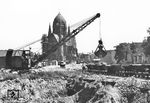 Arbeiten mit einer Lorenbahn in der Blücherstraße in der amerikanischen Zone von Berlin. Im Hintergrund die Kirche zum Heiligen Kreuz. Das Bild zeigt vermutlich die Vorbereitungen und Räumarbeiten für das Fundament der Amerika-Gedenk-Bibliothek in Berlin Kreuzberg. Die Grundsteinlegung war am 29. Juni 1952, sechs Tage nach dem Aufnahmedatum. Die Bibliothek war ein Geschenk der Vereinigten Staaten und wurde aus Mitteln des Marshall-Plans gestiftet und sollte ein Symbol für Bildungs- und Meinungsfreiheit sein. Heute ist sie Bestandteil der Zentral- und Landesbibliothek Berlin. (23.06.1952) <i>Foto: Al Cocking (ACME)</i>